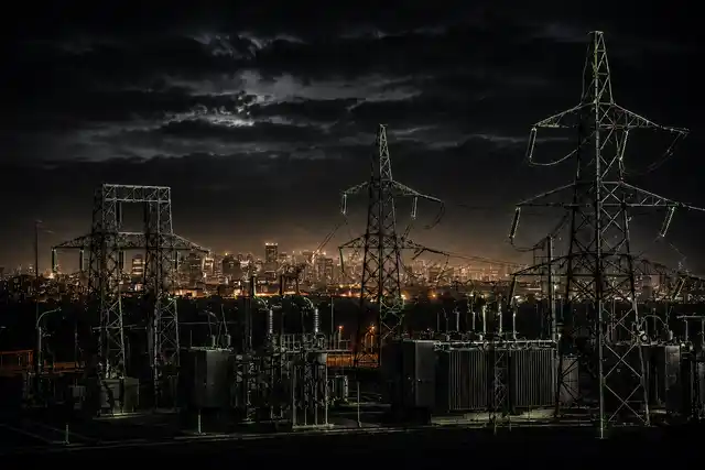 Electrical substation at night with city skyline